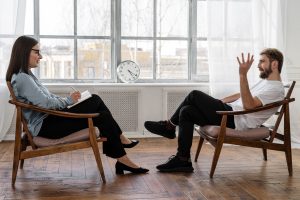 person-in-black-pants-and-black-shoes-sitting-on-brown-4101143-2-300x200